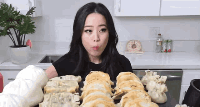 a woman is sitting in front of a table full of food