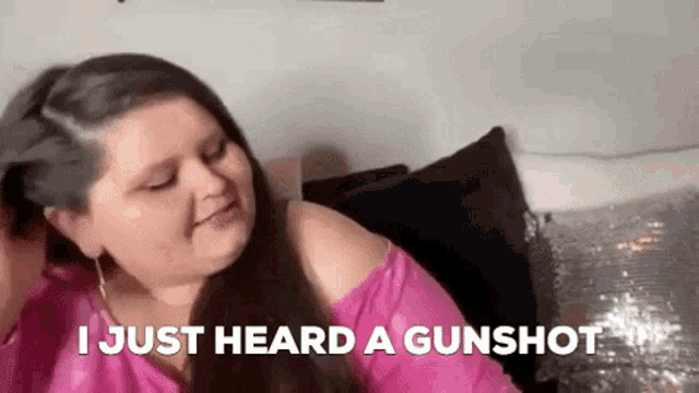 a woman in a pink shirt is sitting on a couch with the words `` i just heard a gunshot '' .