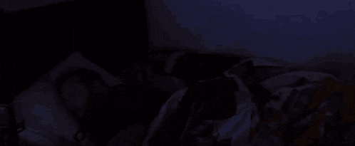 a man with a beard is sleeping in a bed with a blanket that says ' monkey ' on it