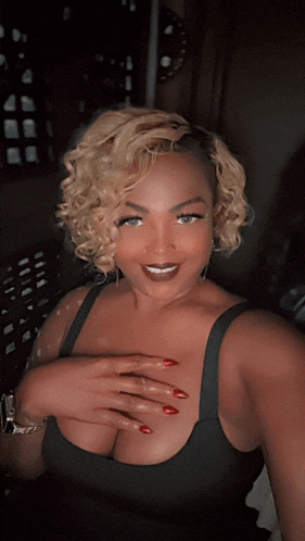 a woman in a black tank top with red nails