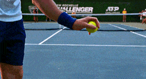 a tennis player holds a tennis ball in front of a sign that says challenger on it