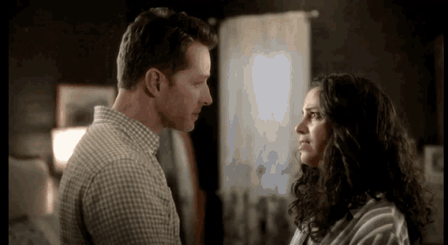 a man and woman are looking at each other in a room