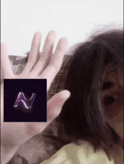 a person is holding up their hand in front of a picture of a glowing letter n .