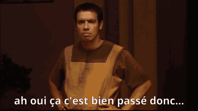 a man is standing in a dark room with the words ah oui ca c'est bien passe donc