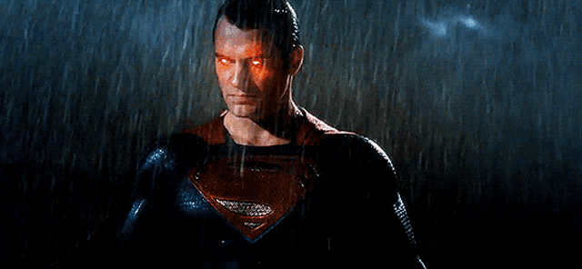 a man in a superman suit is standing in the rain .