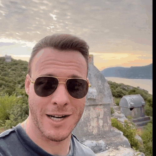 a man wearing sunglasses looks at the camera