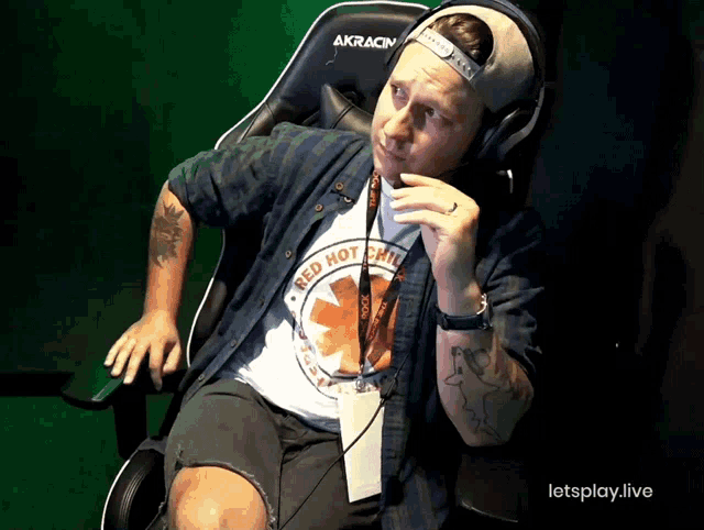 a man wearing headphones and a lanyard that says letsplay.live