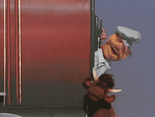 a stuffed animal is sticking its head out of a red truck door