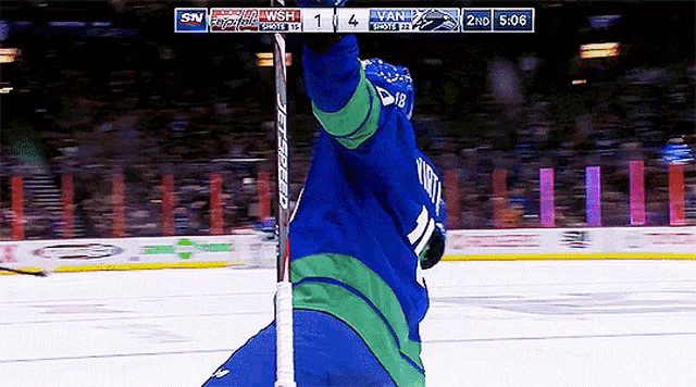 a hockey player with the number 21 on his jersey holds his stick up