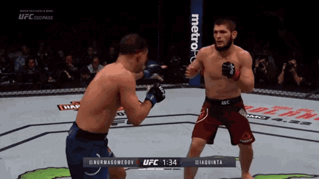 two men are fighting in a boxing ring and the ufc logo can be seen in the background