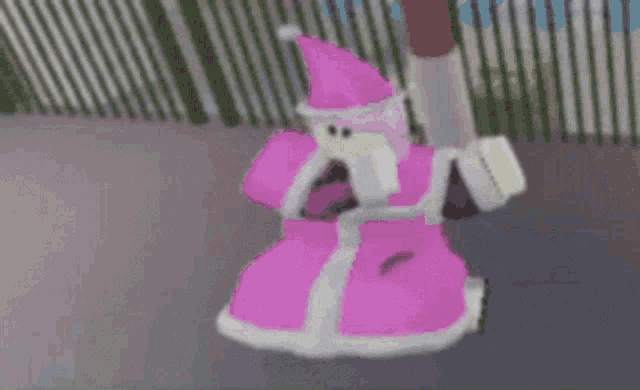 a pink and white santa claus costume is hanging from a fence