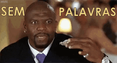 a man in a suit and tie is holding something in his hand and the words sem palavras are above him .