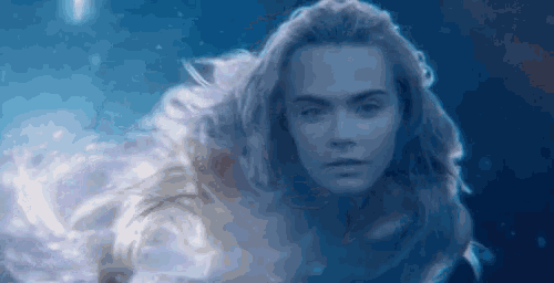 a close up of a woman 's face floating in the water .
