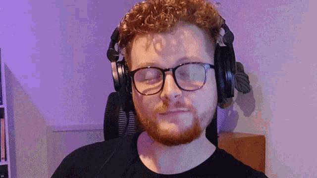 a man wearing headphones and glasses is giving a thumbs up