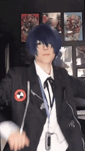 a person in a cosplay costume is standing in front of a wall with posters .