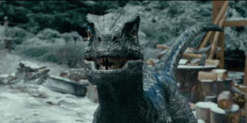 a close up of a dinosaur with its mouth open in the snow