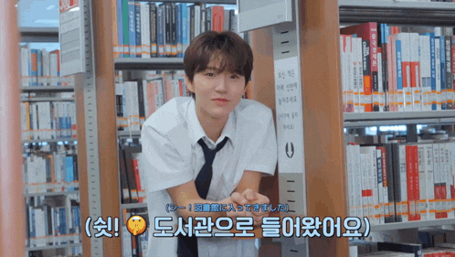 a boy in a library with a sign that says ' a ' on it