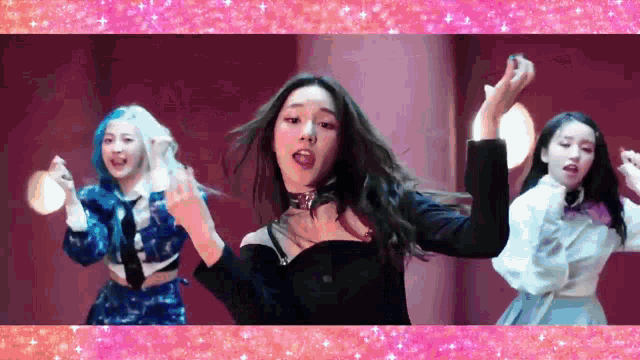 a group of young women are dancing together in a room with a pink background .
