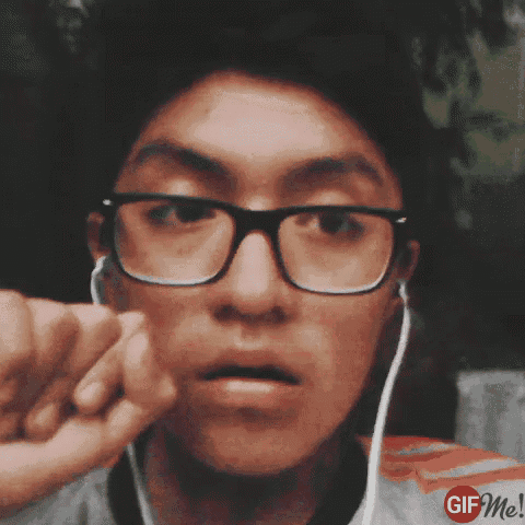 a young man wearing glasses and earbuds is making a face