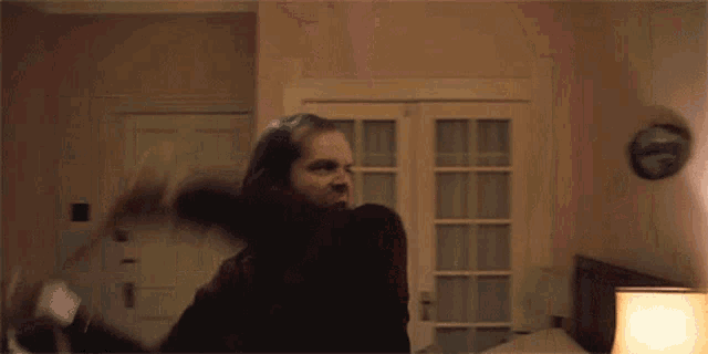 a man is holding a bat in a bedroom .