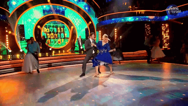 a man and woman are dancing on a stage with dancing brasil written on the bottom