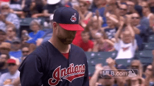 a man wearing an indians baseball uniform stands in front of a crowd