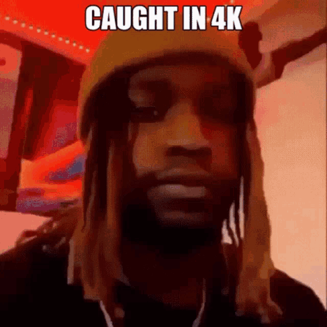 a man with dreadlocks is wearing a yellow beanie and has the words caught in 4k on his face