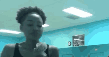 a woman is standing in a room with blue walls holding a piece of paper in her hand .