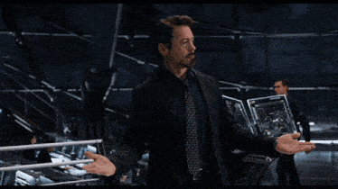 a man in a purple shirt talks to another man in a black shirt