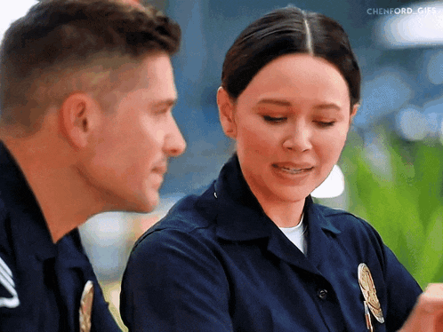 a man and a woman in police uniforms looking at each other