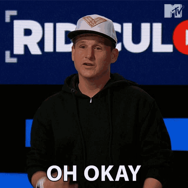 a man wearing a white hat says oh okay in front of a mtv logo