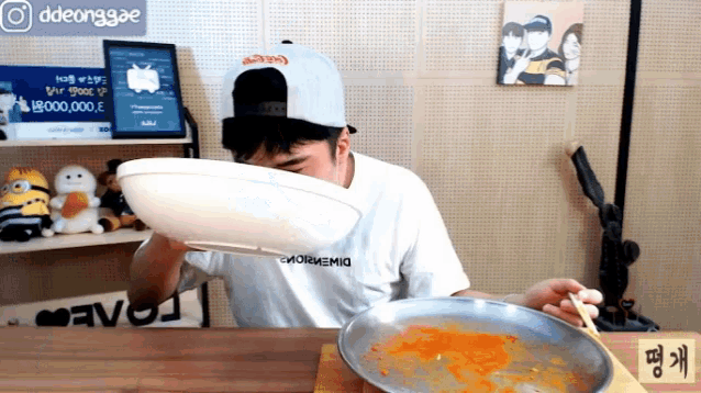 a man wearing a coca cola hat is eating a plate