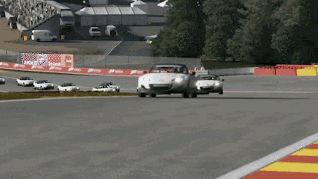 a race track with a lot of cars and a sign that says ' acura ' on it