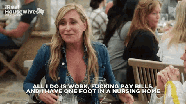 a woman sitting at a table with a caption that says " all i do is work "