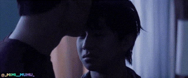 a man and a woman are kissing in the dark .