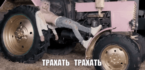 a man laying on top of a pink tractor with the words traxatb traxatb written on the bottom