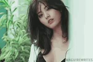 a woman in a black bra is looking at the camera .