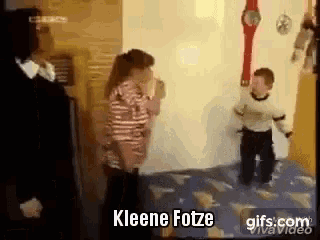 a woman and a boy are standing next to each other on a bed in a room .