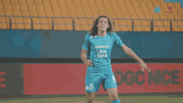 a soccer player wearing a blue jersey that says marseille on it