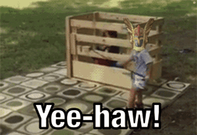 a child standing in front of a wooden fence with yee-haw written on it
