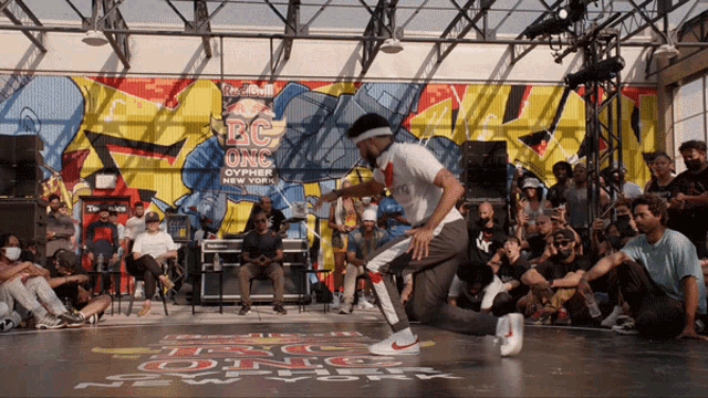 a man dancing in front of a wall that says red bull