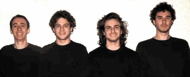 four young men wearing black shirts are standing in a row