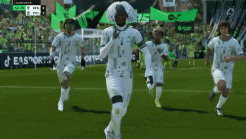 a group of soccer players are running on a field with a banner that says easport on it