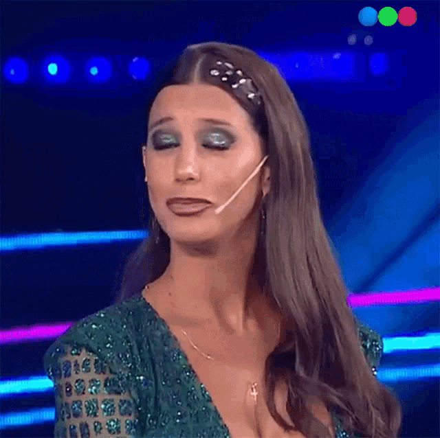 a woman in a green dress is making a funny face with her mouth open