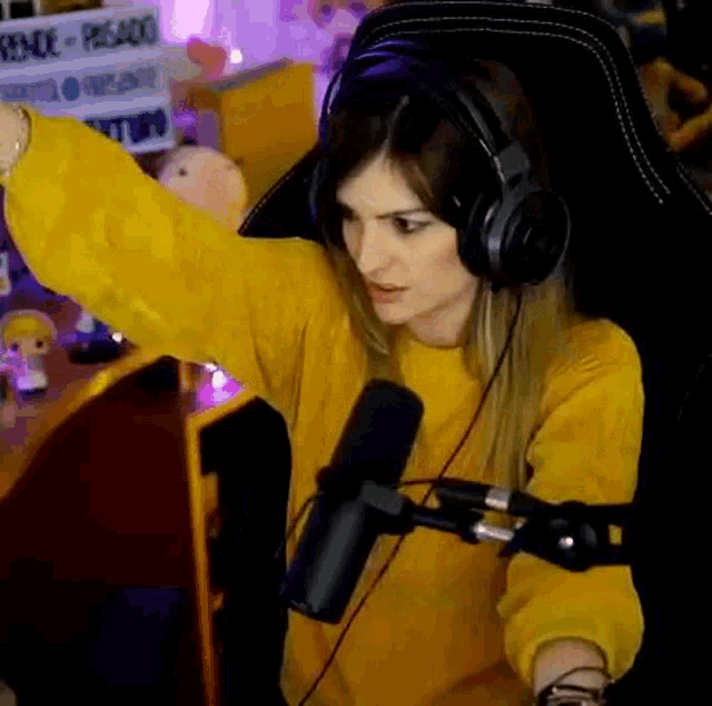 a woman wearing headphones is sitting in front of a microphone .