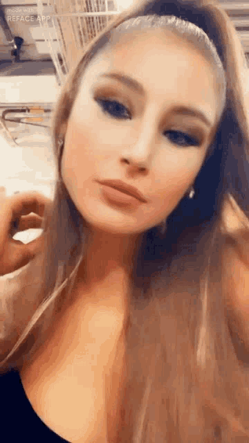 a close up of a woman 's face with a ponytail and earrings .