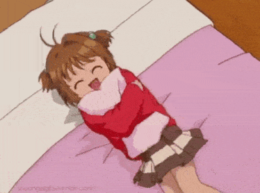 a little girl is laying on a bed with a pillow around her neck .