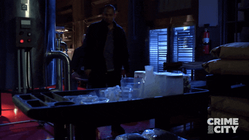 a man is walking in a dark room with the words crime city behind him