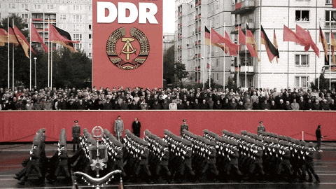 soldiers march in front of a sign that says ddr on it