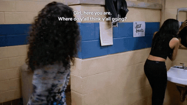 two women in a bathroom with a sign on the wall that says clear fruits